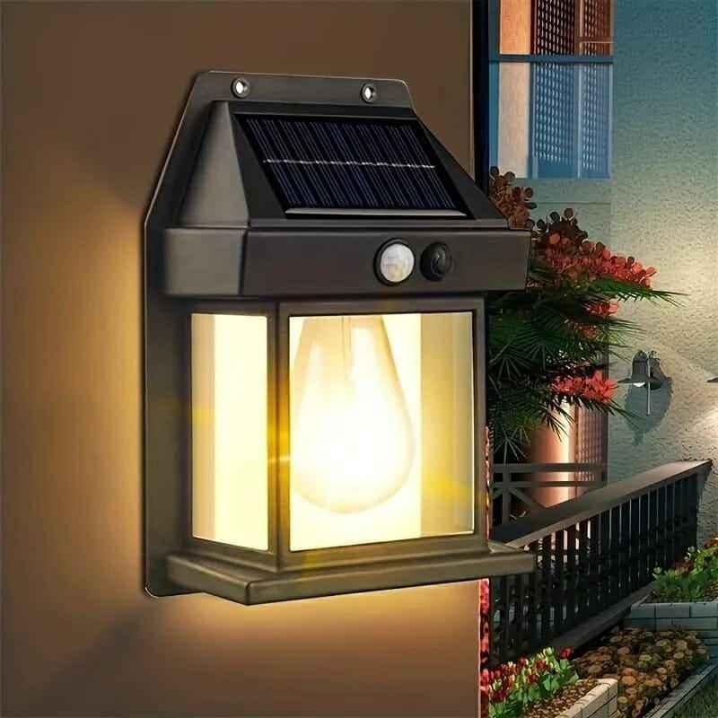 Black solar motion-sensor wall lantern lit on an outdoor wall