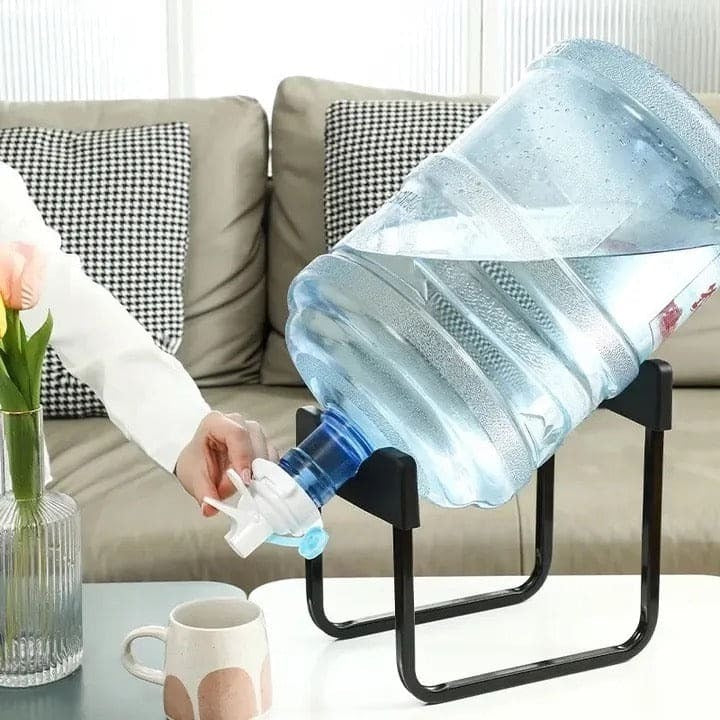 Pouring water into a mug using the stand and tap; bottle and mug shown for demonstration and not included